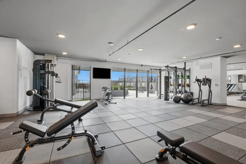 Modern cardio room with treadmills, bikes, and bright lighting.